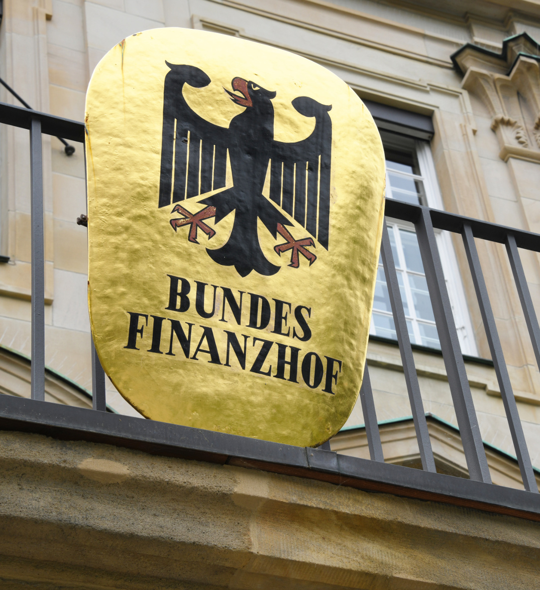 Ein Güldenes Siegel an einer Hausfassade, inmitten der Deutsche Adler, unter welchem die Lettern Bundesfinanzhof prangern.